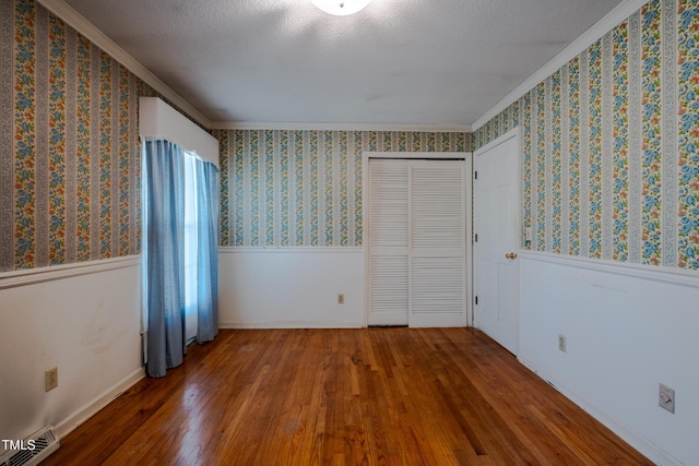 3129 Barwell Rd, Raleigh, NC 27610 - unfurnished bedroom featuring crown molding, wood finished floors, a wainscoted wall, and wallpapered walls