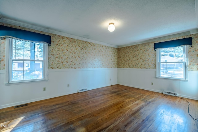 3129 Barwell Rd, Raleigh, NC 27610 - spare room featuring wallpapered walls, crown molding, wood finished floors, a textured ceiling, and wainscoting