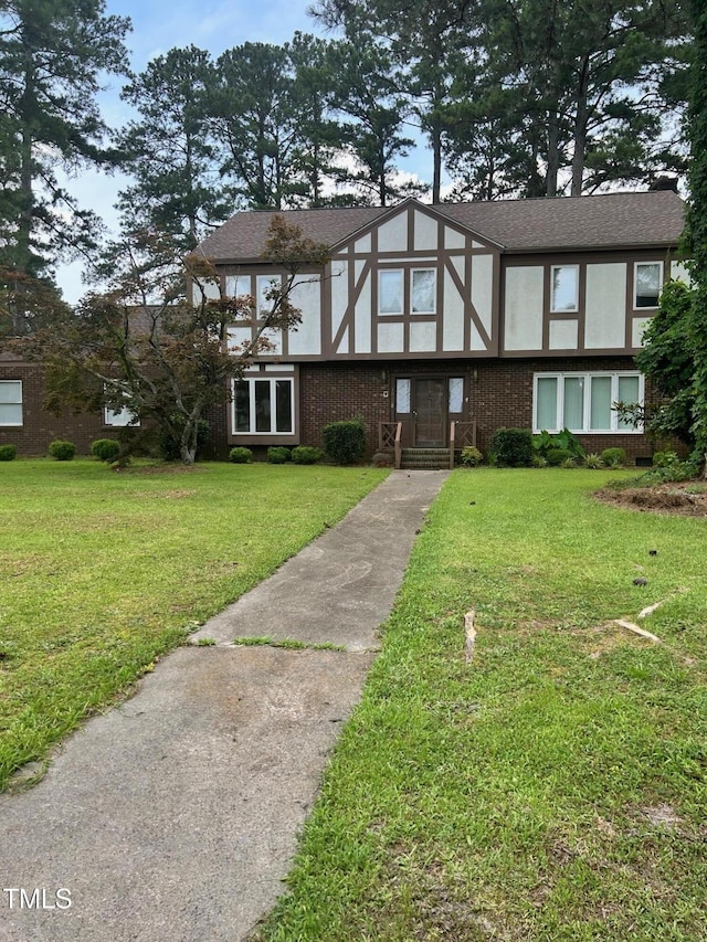 1800 Windsor Rd, Kinston, NC 28504 - tudor house featuring a front lawn, stucco siding, and brick siding