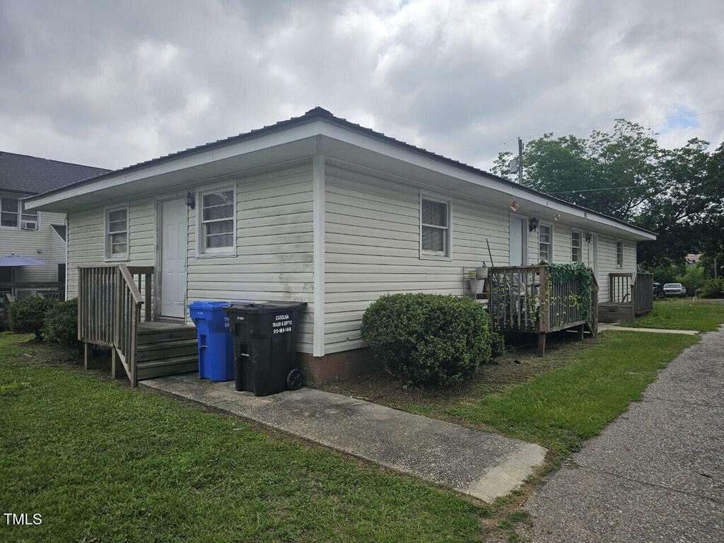 401 S Raleigh St A-B, Unit A-B Angier, NC 27501 - view of side of property featuring a wooden deck, a metal roof, and a lawn