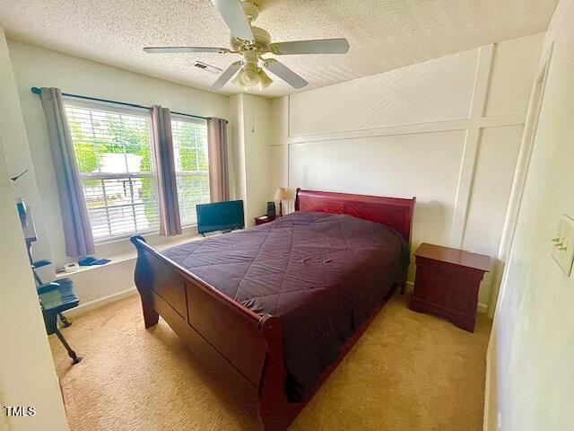 6328 Bermuda Way, Whitsett, NC 27377 - bedroom featuring carpet flooring, a textured ceiling, and a ceiling fan