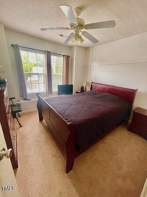 6328 Bermuda Way, Whitsett, NC 27377 - bedroom with light carpet, a textured ceiling, and a ceiling fan