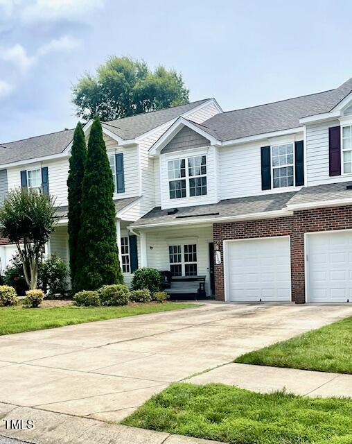 6328 Bermuda Way, Whitsett, NC 27377 - view of front of property with a garage, concrete driveway, and brick siding