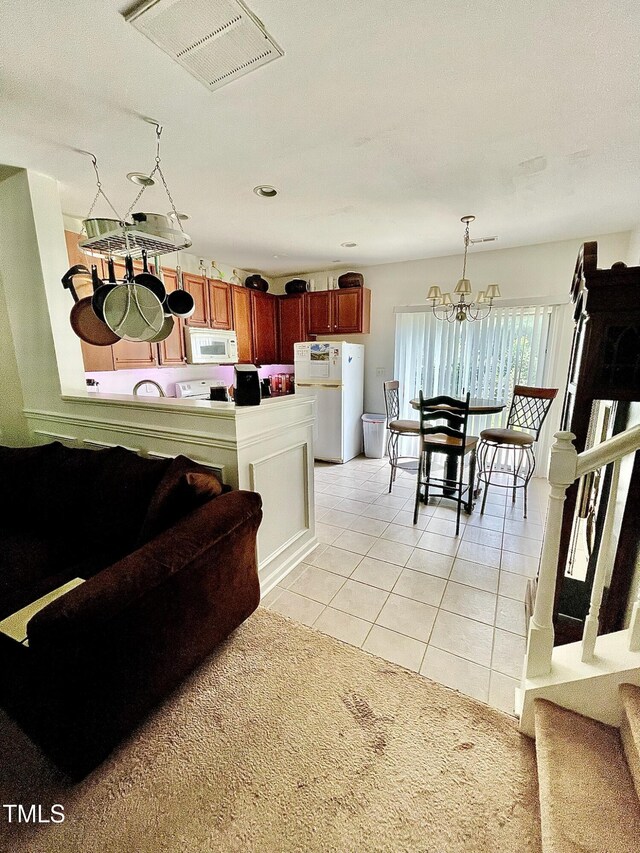 6328 Bermuda Way, Whitsett, NC 27377 - kitchen with white appliances, light tile patterned flooring, a chandelier, reddish brown cabinets, and pendant lighting