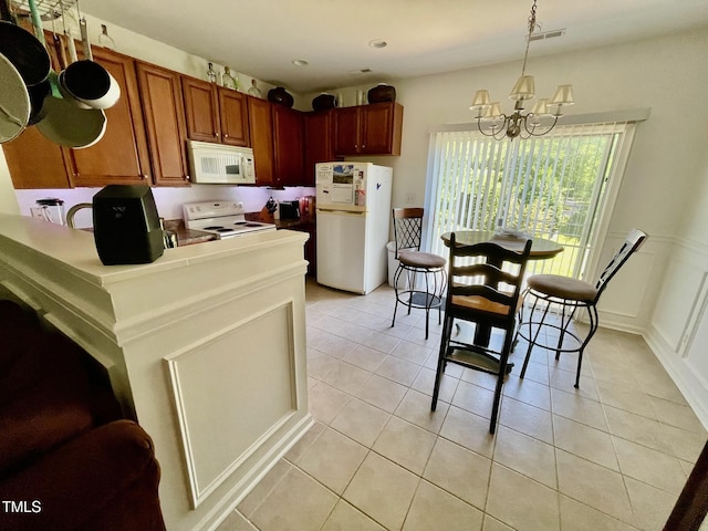 6328 Bermuda Way, Whitsett, NC 27377 - kitchen featuring white appliances, a chandelier, light tile patterned floors, brown cabinets, and hanging light fixtures