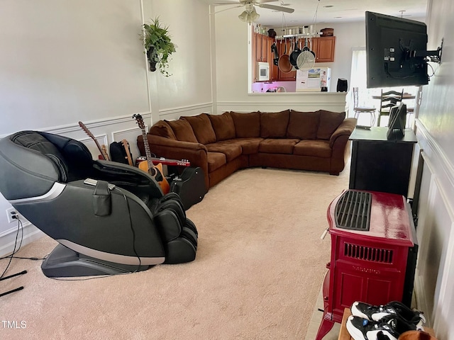 6328 Bermuda Way, Whitsett, NC 27377 - carpeted living room with a ceiling fan, a decorative wall, and wainscoting