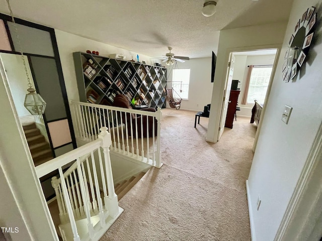6328 Bermuda Way, Whitsett, NC 27377 - hall with an upstairs landing, carpet, and a textured ceiling