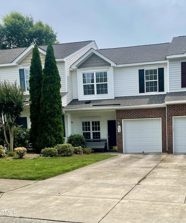 6328 Bermuda Way, Whitsett, NC 27377 - view of front of property with concrete driveway, a garage, a front lawn, brick siding, and a shingled roof