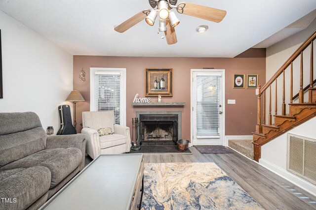 5538 Sharpe Dr, Raleigh, NC 27612 - living area featuring a ceiling fan, wood finished floors, stairs, and a fireplace with flush hearth