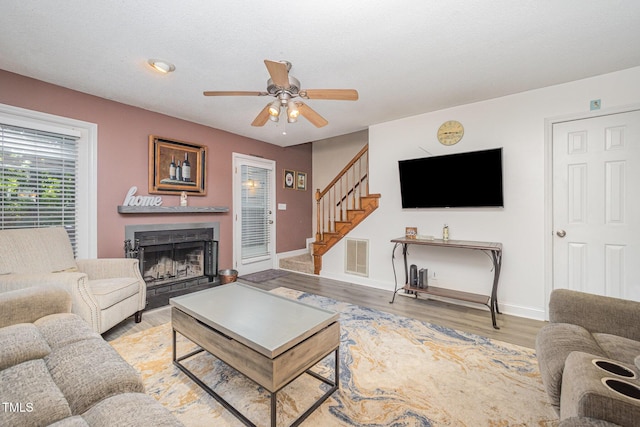 5538 Sharpe Dr, Raleigh, NC 27612 - living room with stairs, a ceiling fan, a fireplace, and light wood finished floors