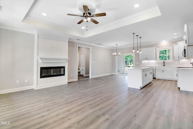 157 Cherrybirch Ln, Zebulon, NC 27597 - kitchen featuring open floor plan, a ceiling fan, a kitchen island, a raised ceiling, and tasteful backsplash