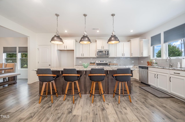 23 Walker Grove Ln, Lillington, NC 27546 - kitchen featuring stainless steel appliances, decorative backsplash, wood finished floors, white cabinetry, and recessed lighting