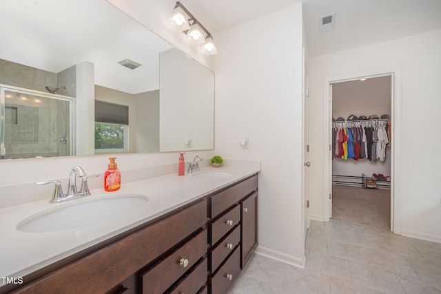 23 Walker Grove Ln, Lillington, NC 27546 - full bathroom featuring double vanity, a shower stall, tile patterned flooring, and a walk in closet