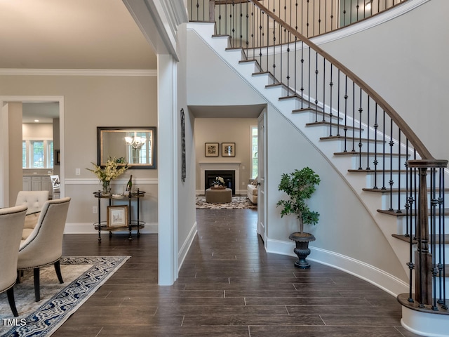 3526 Clifton Park Ct, New Hill, NC 27562 - entryway featuring ornamental molding, wood finished floors, stairs, a fireplace, and a towering ceiling