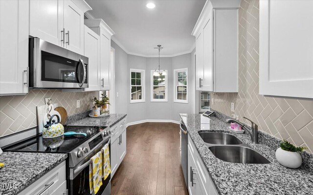 213 Guerrant St, Greensboro, NC 27401 - kitchen featuring stainless steel appliances, white cabinetry, dark wood-style flooring, backsplash, and ornamental molding