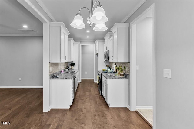 213 Guerrant St, Greensboro, NC 27401 - kitchen with stainless steel appliances, a chandelier, white cabinetry, decorative backsplash, and crown molding