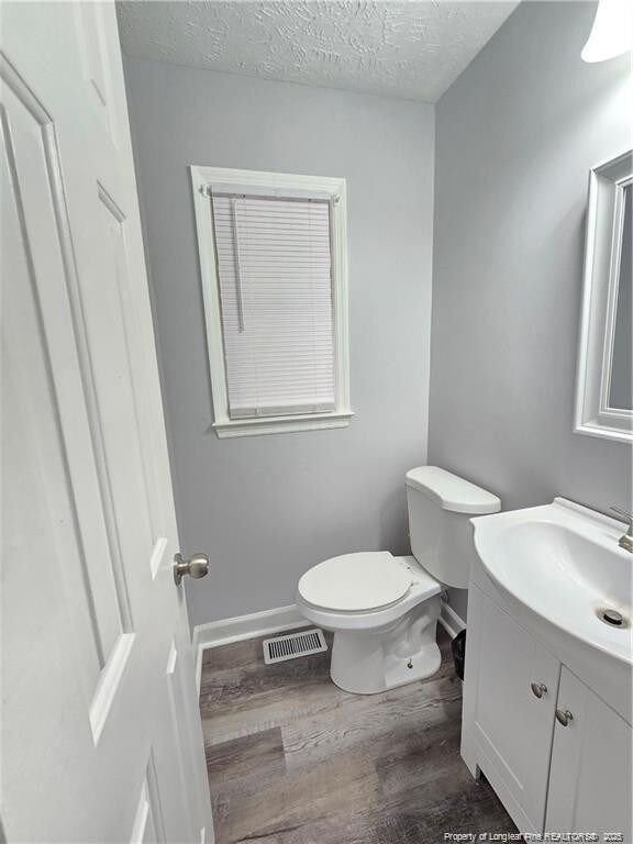 1654 Baysden Ct, Fayetteville, NC 28303 - bathroom with vanity, wood finished floors, and a textured ceiling