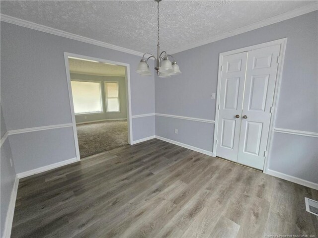 1654 Baysden Ct, Fayetteville, NC 28303 - unfurnished dining area featuring a chandelier, wood finished floors, a textured ceiling, and crown molding