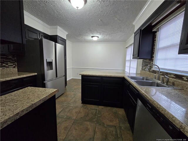 1654 Baysden Ct, Fayetteville, NC 28303 - kitchen featuring appliances with stainless steel finishes, dark cabinets, decorative backsplash, a peninsula, and a textured ceiling