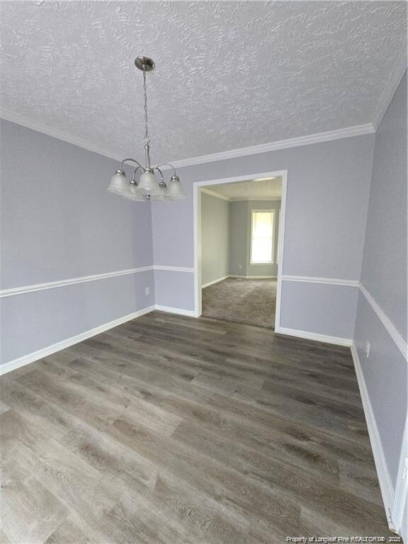 1654 Baysden Ct, Fayetteville, NC 28303 - unfurnished dining area with a chandelier, wood finished floors, ornamental molding, and a textured ceiling