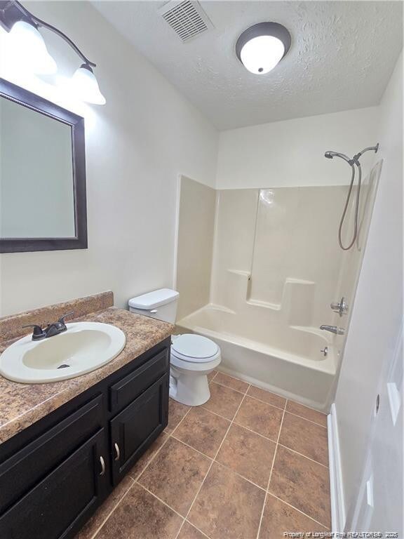 1654 Baysden Ct, Fayetteville, NC 28303 - full bath with vanity, a textured ceiling, shower / bathtub combination, and tile patterned flooring