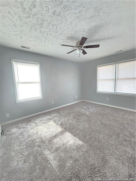 1654 Baysden Ct, Fayetteville, NC 28303 - unfurnished room with healthy amount of natural light, a ceiling fan, carpet, and a textured ceiling