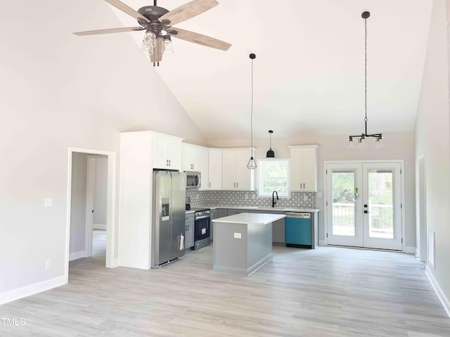 341 Rev Henderson Rd, Henderson, NC 27537 - kitchen with stainless steel appliances, backsplash, a kitchen island, light wood finished floors, and light countertops