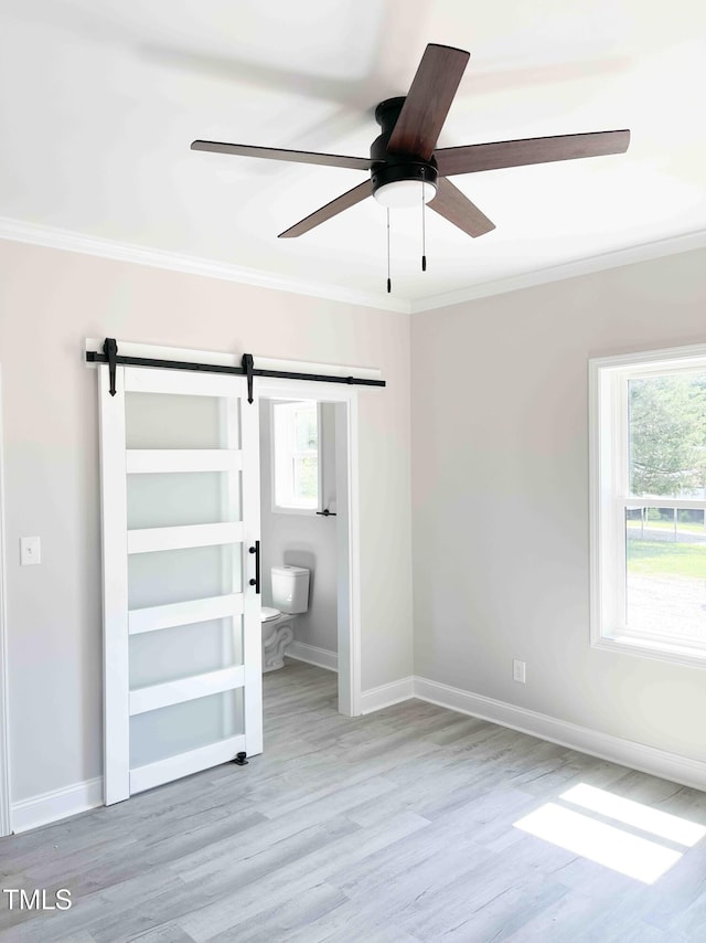 341 Rev Henderson Rd, Henderson, NC 27537 - unfurnished bedroom featuring a barn door, crown molding, wood finished floors, and ceiling fan