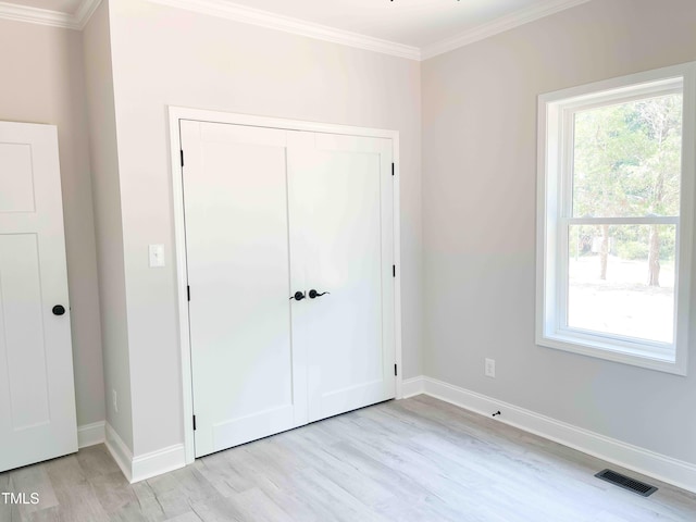 341 Rev Henderson Rd, Henderson, NC 27537 - unfurnished bedroom featuring ornamental molding, light wood-style flooring, multiple windows, and a closet