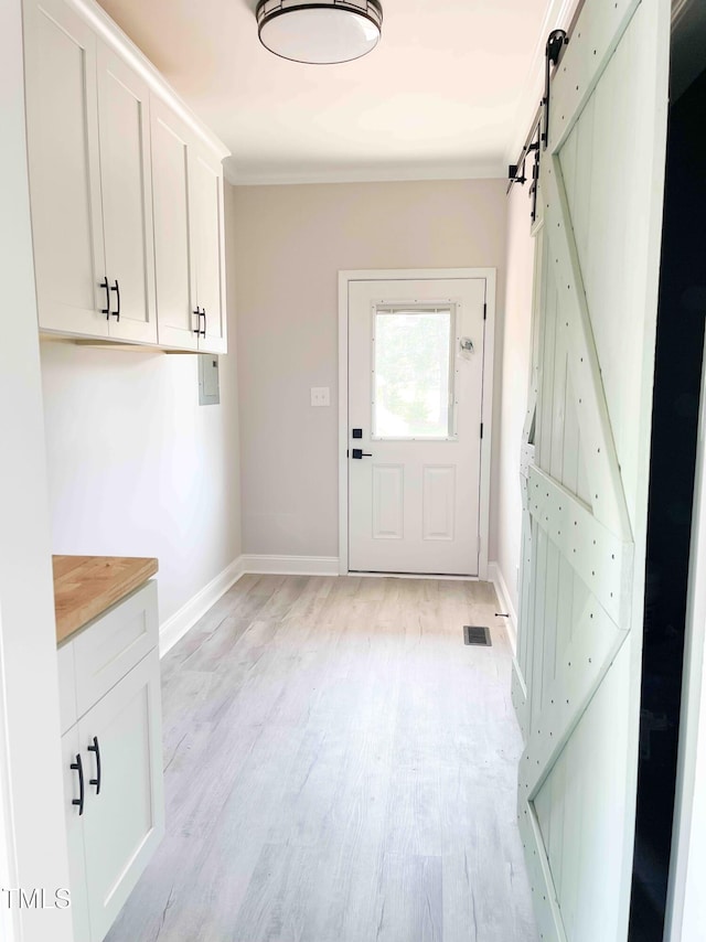 341 Rev Henderson Rd, Henderson, NC 27537 - doorway featuring a barn door, light wood-style flooring, and ornamental molding