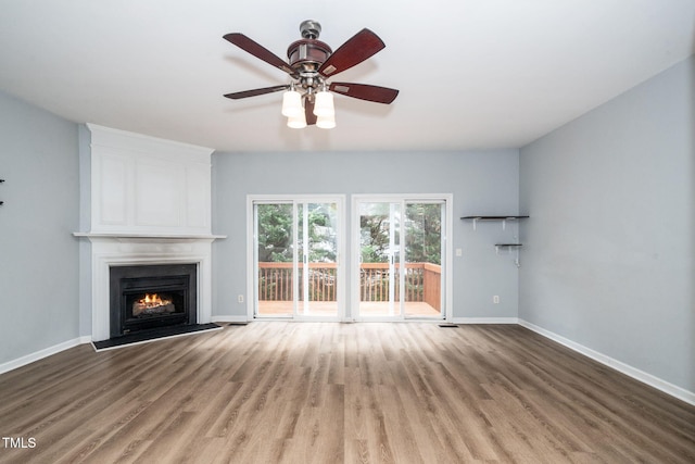 7226 Corvette Ct, Raleigh, NC 27613 - unfurnished living room with wood finished floors, a large fireplace, and ceiling fan