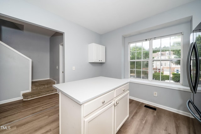 7226 Corvette Ct, Raleigh, NC 27613 - kitchen with dark wood finished floors, white cabinetry, freestanding refrigerator, light countertops, and a center island