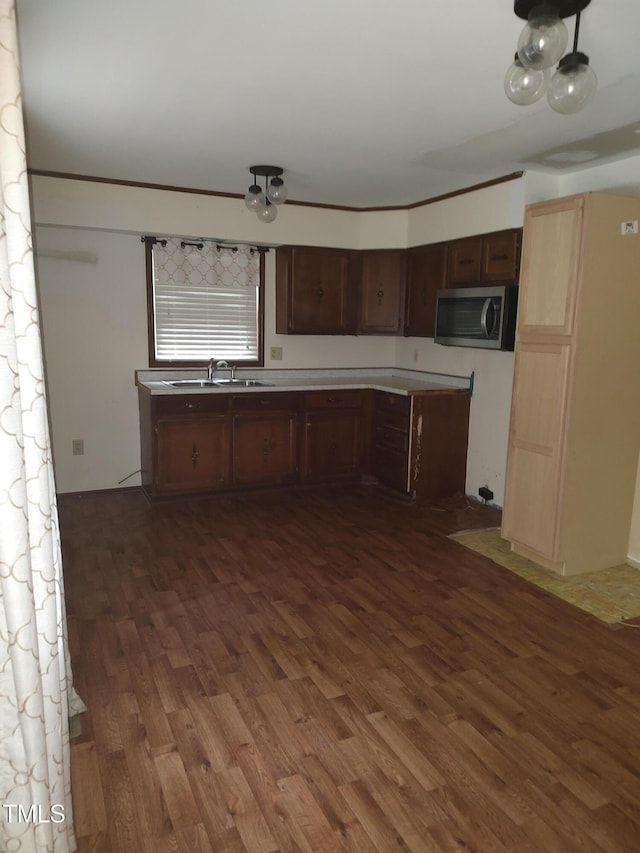 1161 Morgan Rd, Henderson, NC 27537 - kitchen with dark wood-type flooring, stainless steel microwave, light countertops, and dark brown cabinetry