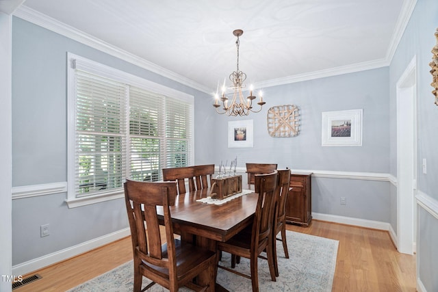 2608 Forestbluff Dr, Fuquay Varina, NC 27526 - dining space with a chandelier, light wood-style flooring, and crown molding