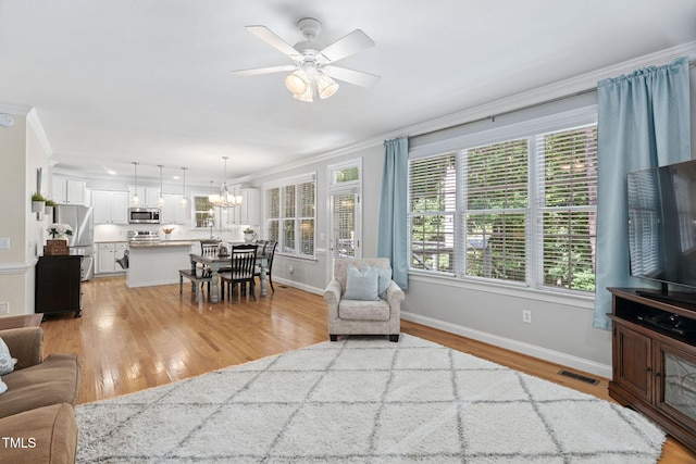 2608 Forestbluff Dr, Fuquay Varina, NC 27526 - living area with crown molding, light wood-style flooring, a ceiling fan, and a chandelier
