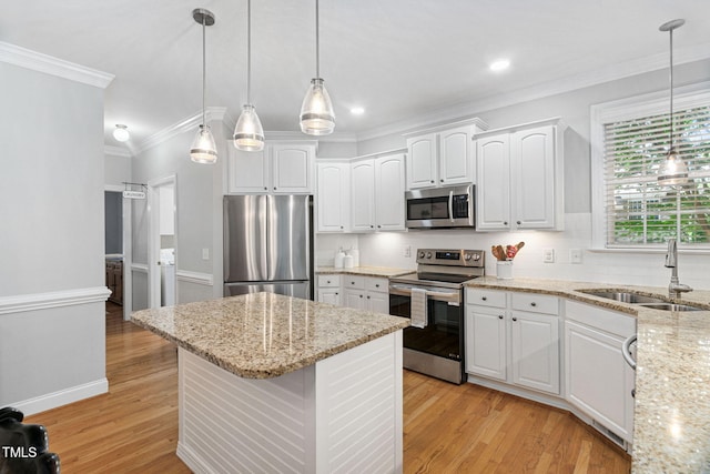 2608 Forestbluff Dr, Fuquay Varina, NC 27526 - kitchen featuring stainless steel appliances, ornamental molding, white cabinetry, tasteful backsplash, and light wood-type flooring