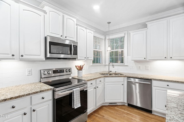 2608 Forestbluff Dr, Fuquay Varina, NC 27526 - kitchen featuring stainless steel appliances, white cabinets, decorative backsplash, light stone countertops, and crown molding