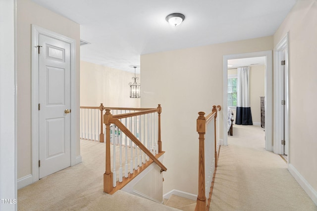2608 Forestbluff Dr, Fuquay Varina, NC 27526 - hallway with an upstairs landing, light colored carpet, and a chandelier