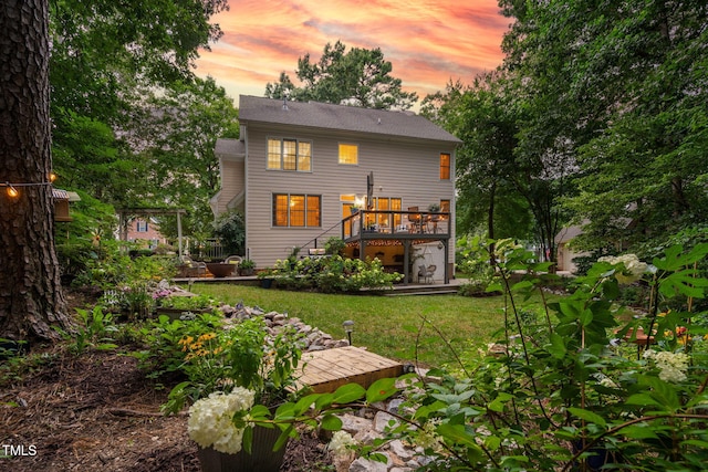 2608 Forestbluff Dr, Fuquay Varina, NC 27526 - back of property at dusk featuring a wooden deck, stairway, and a lawn