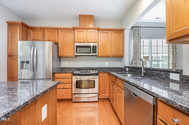 732 Hornchurch Loop, Cary, NC 27519 - kitchen featuring stainless steel appliances, light wood-style flooring, brown cabinets, and dark stone countertops