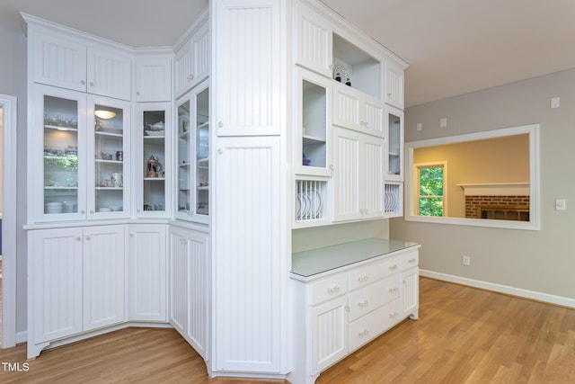 900 Stonecutter Ct, Raleigh, NC 27614 - kitchen featuring light wood-type flooring, glass insert cabinets, white cabinetry, and light countertops