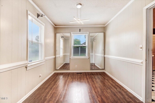 607 E Geer St, Durham, NC 27701 - unfurnished dining area featuring wood finished floors, ornamental molding, a textured ceiling, and wood walls