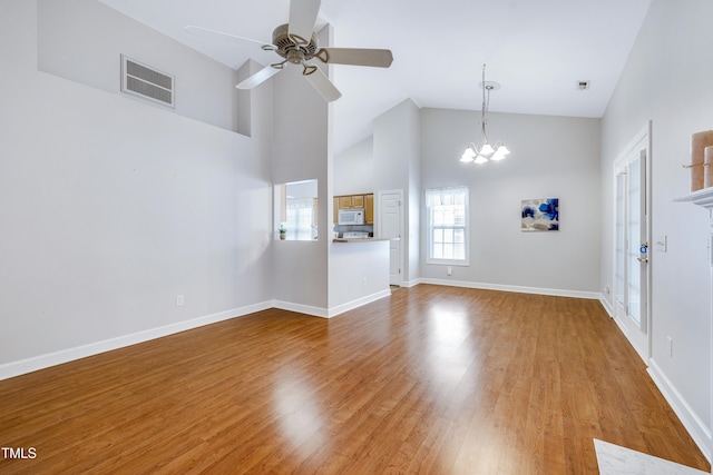 325 Millet Dr, Morrisville, NC 27560 - unfurnished living room featuring a chandelier, ceiling fan, high vaulted ceiling, and wood finished floors