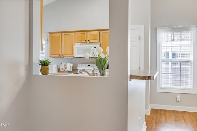 325 Millet Dr, Morrisville, NC 27560 - kitchen with white microwave, range, light wood-style flooring, light countertops, and light brown cabinetry