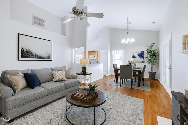 325 Millet Dr, Morrisville, NC 27560 - living area featuring a chandelier, light wood-style floors, ceiling fan, and high vaulted ceiling