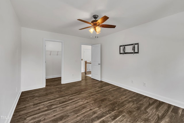 211 Camille Cir, Youngsville, NC 27596 - unfurnished bedroom with dark wood-style floors, a spacious closet, and a ceiling fan