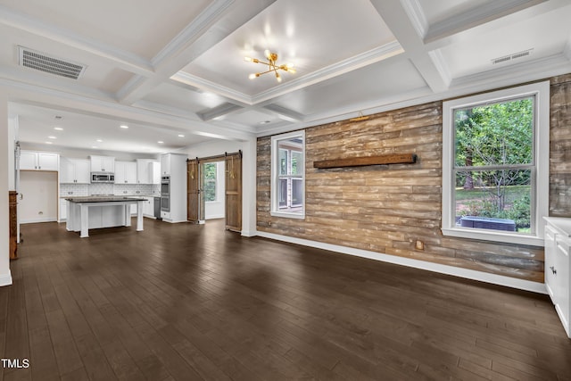 211 Camille Cir, Youngsville, NC 27596 - unfurnished living room featuring a barn door, coffered ceiling, a chandelier, beamed ceiling, and dark wood-type flooring