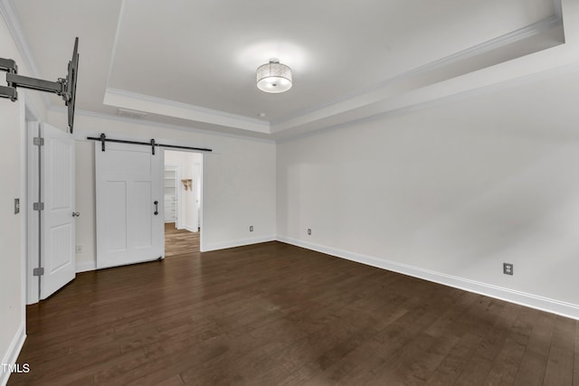 211 Camille Cir, Youngsville, NC 27596 - unfurnished bedroom with a barn door, a tray ceiling, ornamental molding, and dark wood-type flooring