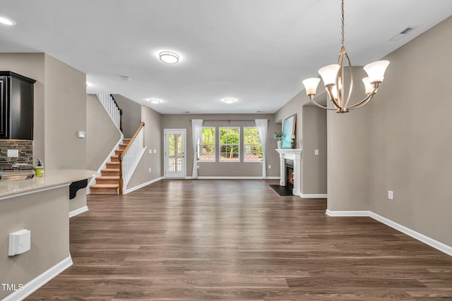 401 Summit Trail Dr, Hillsborough, NC 27278 - unfurnished living room with dark wood-type flooring, stairs, a chandelier, and a fireplace with flush hearth