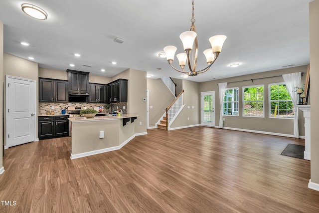 401 Summit Trail Dr, Hillsborough, NC 27278 - kitchen with open floor plan, ventilation hood, wood finished floors, backsplash, and stainless steel stove